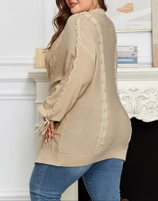 Woman wearing a beige cardigan with lace details in an indoor setting.