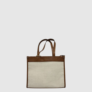 Tote bag with brown leather handle and trim on a light gray background